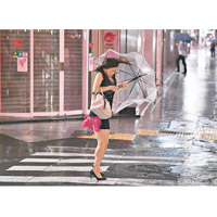 東京一名女子撐傘，力擋狂風暴雨。