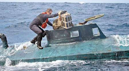 海岸防衞隊隊員爬上潛艇。