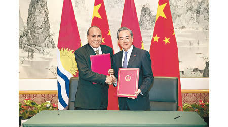 王毅（右）與馬茂（左）簽署聯合公報。（中新社圖片）
