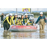 磐城市有居民要坐橡皮艇疏散。（美聯社圖片）