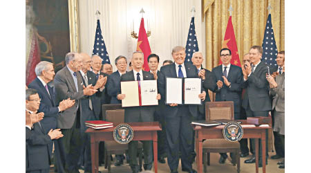 劉鶴與特朗普展示已簽署的貿易協議。（中新社圖片）