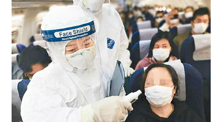 專家指眼部存在傳染風險，圖為飛機乘務員為乘客量體溫。