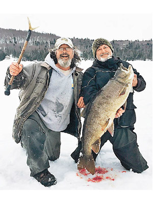 奈特（右）與漁業生物學家及大魚合照。