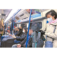 英國:民眾坐地鐵時均戴上口罩。（美聯社圖片）