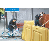 武漢市民途經一處檢查關卡。（美聯社圖片）
