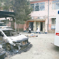 醫院外有汽車焚毀。 （美聯社圖片）