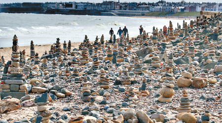 沿島海岸排列的卵石塔大小各異。（美聯社圖片）