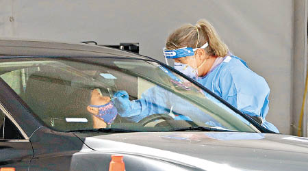 佛羅里達州疫情反彈，醫護人員為司機抽取樣本檢測。