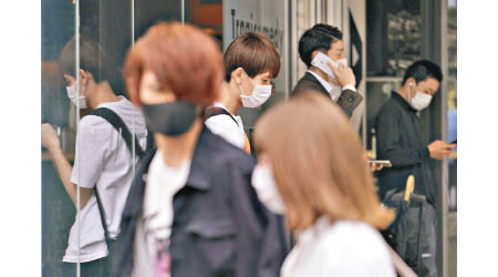 東京市民戴上口罩外出。（美聯社圖片）