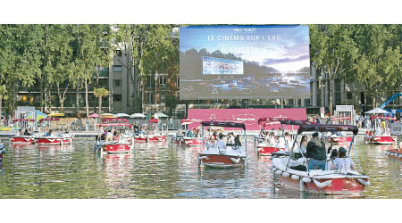 遊人可以在河上小船，或於河岸坐在沙灘椅上觀賞電影。