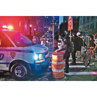 紐約市近日不時爆發反警暴示威，民眾阻止警車向前行。（美聯社圖片）