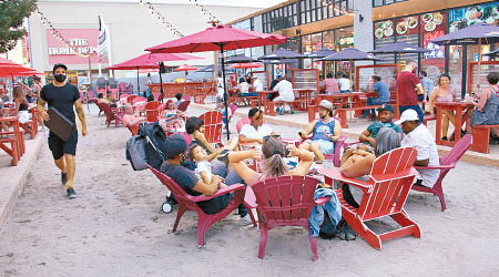 民眾在沙灘主題露天餐飲區享受悠閒一刻。（中新社圖片）