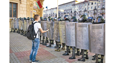 一名示威者站在防暴警員前方。（美聯社圖片）