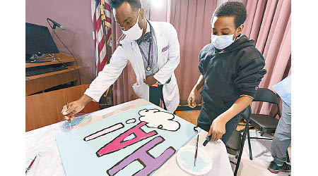 醫生（左）與病童（右）齊為壁畫填色。（美聯社圖片）