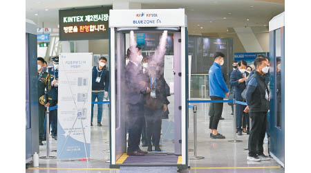 南韓出現新一波疫情。出席展覽會的人士接受消毒。（美聯社圖片）