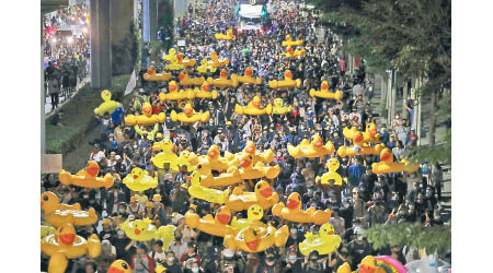 泰國示威者高舉黃色吹氣鴨子公仔。（美聯社圖片）