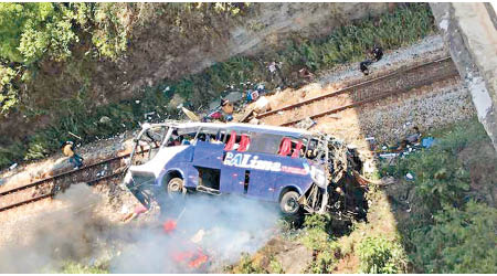 旅遊巴從橋上直墮地面，車身嚴重損毀。