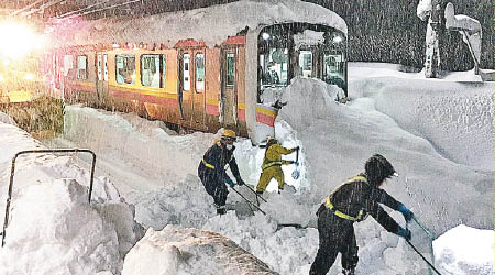 鐵路工人忙於剷雪。