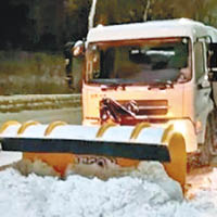 剷雪車和工人通宵清理積雪。