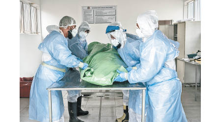 南非醫護人員把病死者的遺體密封。（美聯社圖片）