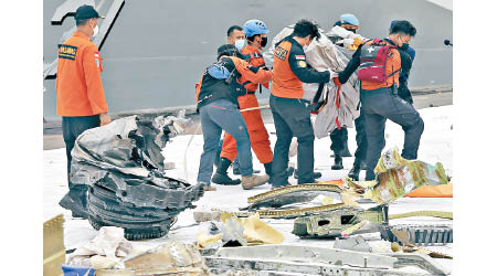 搜救人員繼續打撈客機殘骸。（美聯社圖片）