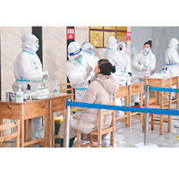 黑龍江：哈爾濱防疫人員替婦人抽取咽喉拭子樣本。