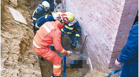 消防員找到一名被埋的工人。
