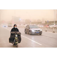 受沙塵天氣影響交通，車輛行駛時大多減慢速度。（中新社圖片）