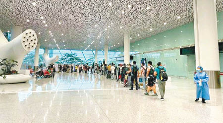 旅客在深圳寶安機場等候接受檢測。
