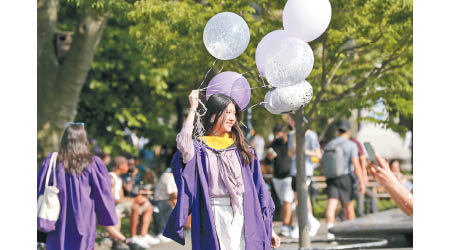 一名紐約大學的中國留學生早前拍攝畢業照。（中新社圖片）