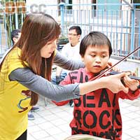 梓岐耐心教真一拉小提琴。