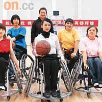翁虹手持籃球，與一班輪椅女籃隊隊員合照。