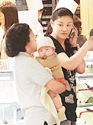 范姜 （右）的小小B女由工人抱着，一臉精靈。