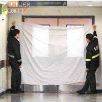 工作人員用白布遮掩ICU門口，防止他人從外面望進。