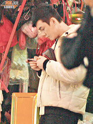 陳偉霆在街上用手機與阿Sa傳情，面露甜笑。