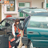 一男一女助手小心將蔡楓華的行李搬上車。