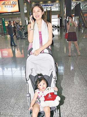 徐淑敏在機場推着女兒，接剛回港的老公。