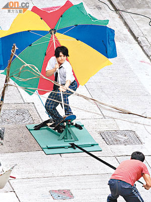 山田涼介執起太陽傘扮踩滑板。