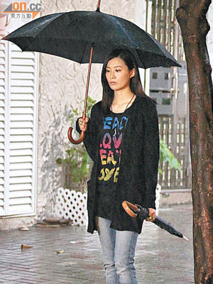 陳法拉打着傘拍攝雨中戲，拍畢後不忘整理頭髮。