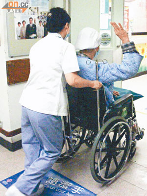 坐在輪椅上的Bobby，以「OK」手勢示意平安，並由醫護人員將他推回病房。