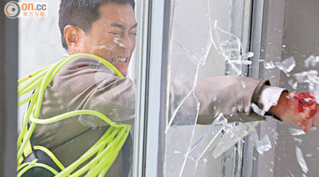 古仔為了救人，一手擊破玻璃窗。
