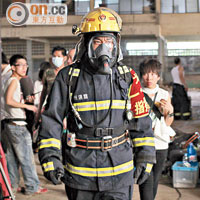 演消防員的青雲，一身裝備入火場。