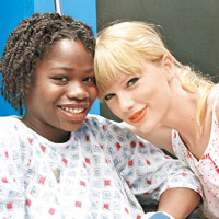 Taylor（右）到醫院探訪患癌病人，捐出5萬美元購買音樂輪椅。（Splash News／東方IC圖片）