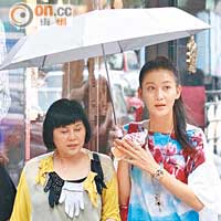 高妹李彩華（右）為友人撐傘子。