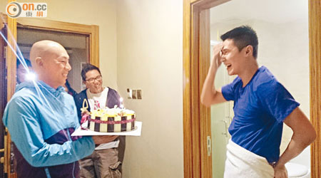 被拍下全裸片段的陳家樂（右），急急腳穿上衫和圍浴巾走出浴室，導演林超賢則捧蛋糕為他慶生。