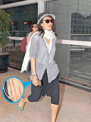 章子怡前日抵達香港機場時面露笑容，見其右手無名指戴上戒指。（CFP圖片）