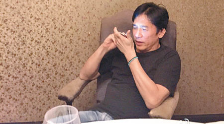 梁朝偉坐在椅上玩手機，被網友笑「聞手機」。