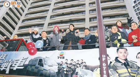 一班《鐵馬戰車》演員坐花車巡遊市區，吸引途人圍觀。