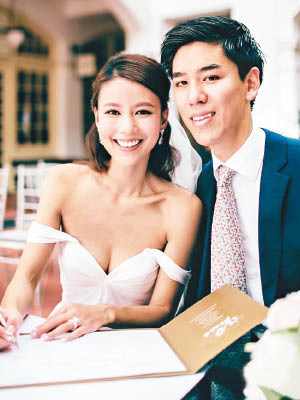 身穿低胸婚紗的李雪瑩與丈夫肩並肩合照。