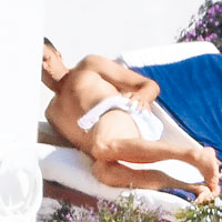 Tom全裸曬太陽，期間圍住毛巾遮遮掩掩。（CFP圖片）